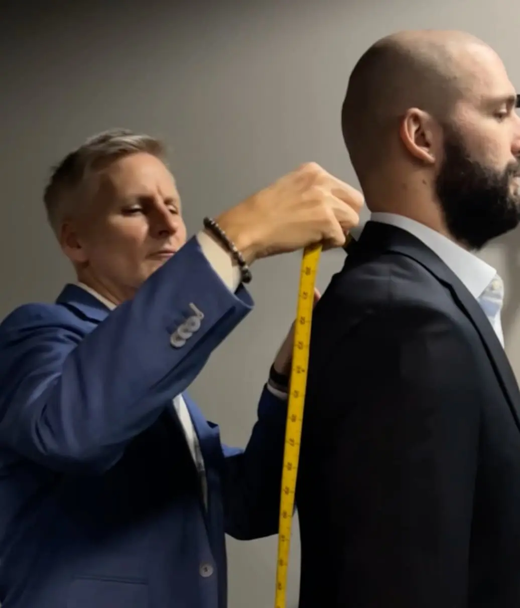Christian Boehm taking shoulder measurements for a bespoke client
